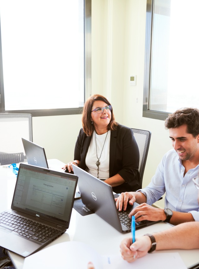 Employees with notebooks at a table in conversation